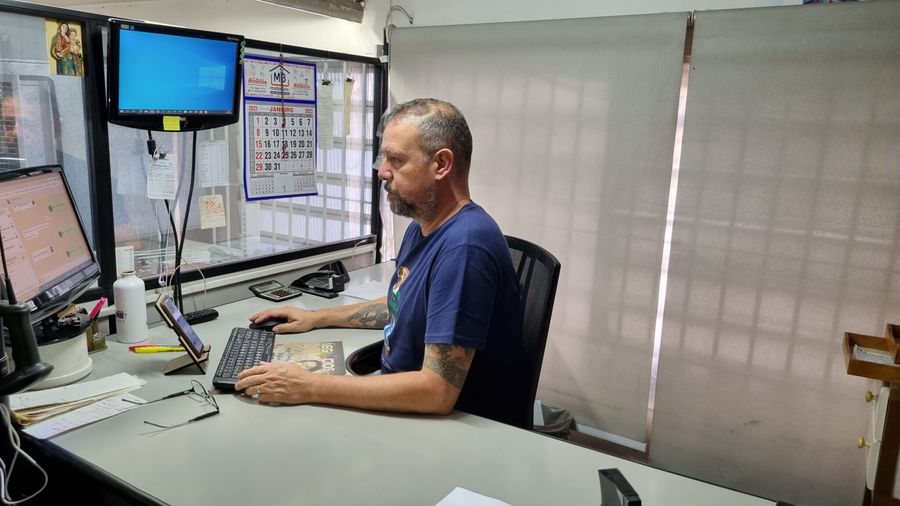 Vendedor da MB Materiais no atendimento, à mesa do computador