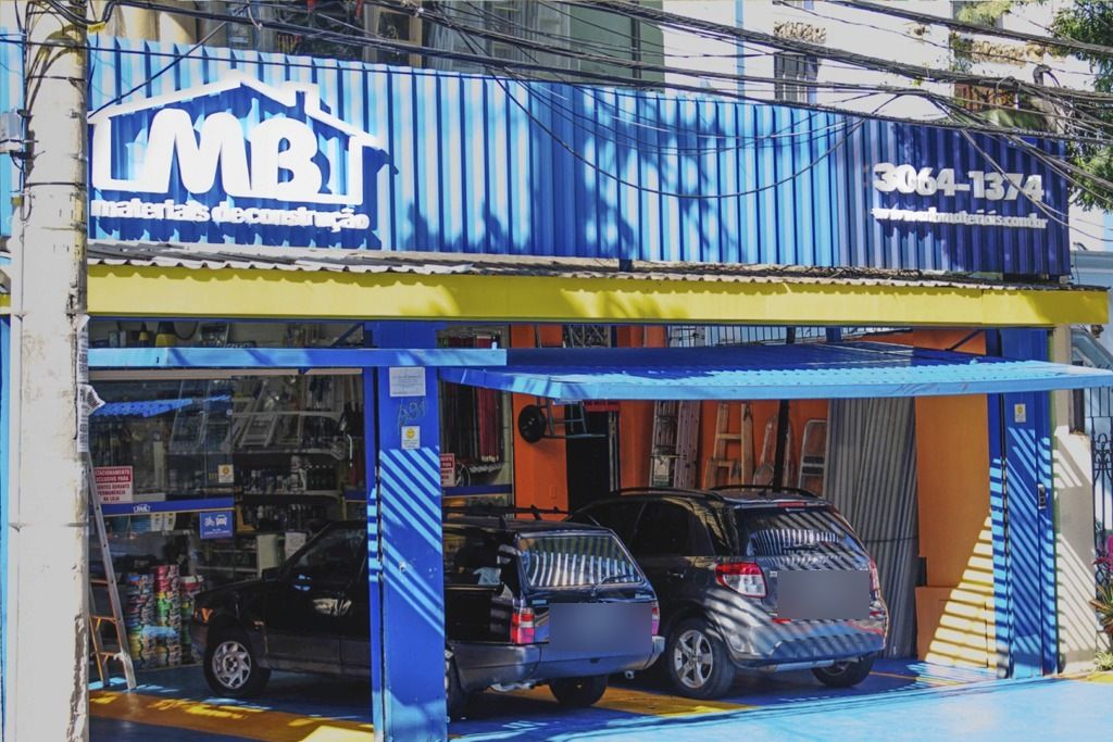 Fachada da loja MB Materiais de Construção em Pinheiros, com vagas de estacionamento na frente